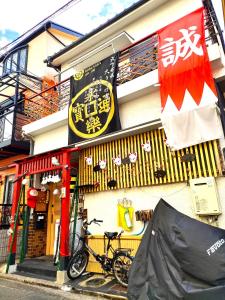 uma bicicleta estacionada em frente a um edifício em MIROKU Share House em Mimiharachō