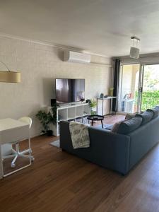 a living room with a couch and a tv at Plush 2 bedroom apartment Kingston in Kingston 