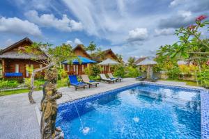 a villa with a swimming pool and a fountain at RR Cottage in Nusa Penida