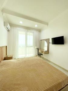 a large bedroom with a large bed and a flat screen tv at Sea View in Astara