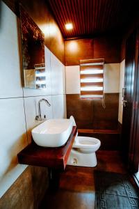 a bathroom with a sink and a toilet at Why Not Houseboat in Alleppey
