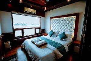 a bedroom with a large bed with a large window at Why Not Houseboat in Alleppey