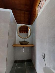 a small bathroom with a mirror and a sink at Les Chalets Pecatu in Uluwatu
