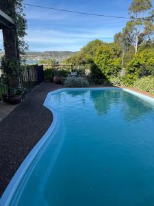 a swimming pool with blue water in a yard at By the Lake - Lake Macquarie in Teralba