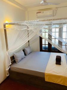 a bed with a canopy in a room at Avalon in Weligama