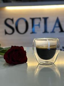 a glass cup of wine next to a red rose at Sofia Hotel in Yerevan