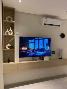a flat screen tv on a wall in a living room at Elegant 3BD Condo near Boulevard in Riyadh