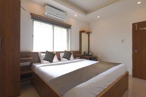 Kama o mga kama sa kuwarto sa Aura Hotel Rajdhani Residency