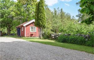 a red shed on the side of a gravel road at Amazing Home In Henn With 1 Bedrooms And Wifi in Henån