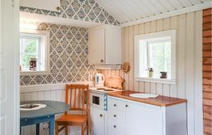 a small kitchen with a counter and a table at Cozy Home In Henn With Kitchen in Henån