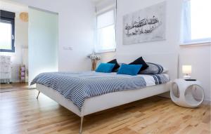 a white bedroom with a large bed with blue pillows at Villa Bianca in Zadar