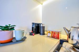 a counter top with a coffee maker and a coffee mug at Cute & Cosy Darwin Waterfront Apartment with Queen Bed in Darwin