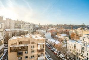 een luchtzicht op een stad met gebouwen en auto's bij Apartment with a panoramic view of Podil near the metro in Kiev
