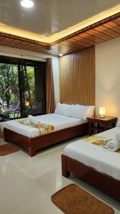Habitación de hotel con 2 camas y ventana en Tinipak Lodge en Tanay