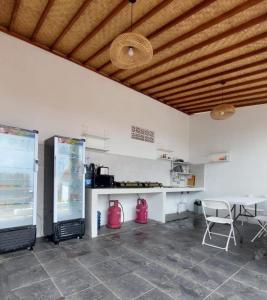 uma cozinha com um balcão, uma mesa e cadeiras em Les Chalets Pecatu em Uluwatu