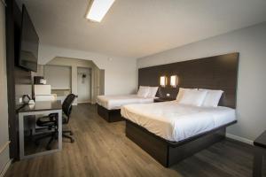 a hotel room with two beds and a desk at Envi Boutique Hotel in Henderson