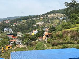 a group of houses on a hill with a blue roof at Perfect Home Stay in Burhānilkantha