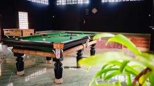 a pool table with balls on it in a room at The Pig Pen Hostel & BBQ in Kampot