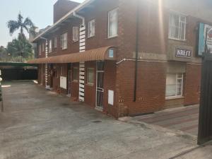 een bakstenen gebouw met een luifel op straat bij Silent Night Guest House Sunnyside Pretoria in Pretoria