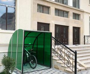 a bike in a green booth next to a building at Boulevard in Sumqayıt