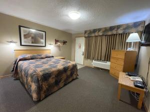 a large hotel room with a bed and a desk at Best Maple Inn - Drayton Valley in Drayton Valley