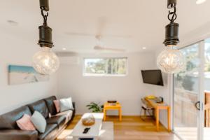 un soggiorno con divano e 2 luci sospese di Private and peaceful house near the Beach a Coolum Beach