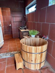 a bathroom with a wooden tub with a plant in it at Mai's House Hữu Lũng in Làng Ben