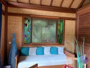 un sofá en una habitación con ventana en Le Nirvana - Oasis de Tendéa - Farino en Farino