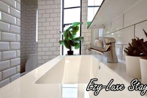 a white sink in a kitchen with a plant at MCG Best Unit For Fireworks 1BR Sleeps3 in Melbourne