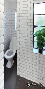 a white bathroom with a toilet and a window at MCG Best Unit For Fireworks 1BR Sleeps3 in Melbourne