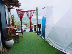 カオコーにあるBlack Diamond Campingの緑の芝生とテーブル、テントのあるパティオ
