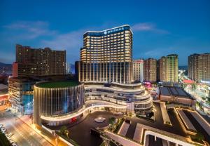 Blick auf ein großes Gebäude in einer Stadt in der Nacht in der Unterkunft Pullman Quanzhou Shuitou in Quanzhou