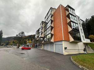 une voiture rouge garée devant un bâtiment dans l'établissement Studio situé au pied des pistes de LaBresse, à La Bresse