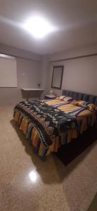 Un dormitorio con una cama con una manta. en DEPARTAMENTO EN PLENO CENTRO DE GUAYAQUIL, en Guayaquil