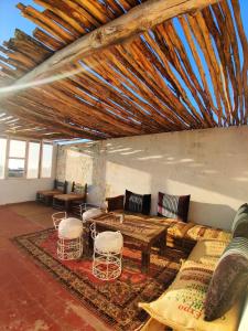 sala de estar con sofá, mesa y sillas en Hippie Chic Room 3, en Sidi Kaouki