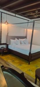 una camera da letto con un grande letto con cuscini bianchi di Malabar Kovilakam a Malappuram