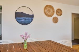 a dining room with a wooden table and mirrors on the wall at Torquay Retreat in Kaikoura