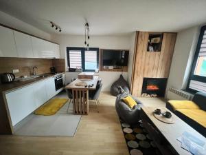 a kitchen and living room with a couch and a table at Apartment Bjelasnica Dream in Bjelašnica
