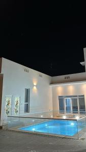 a large swimming pool in a building with a building at Monsoon Chalet - شاليه المونسون in Junayz al Janūbī