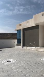 ein Gebäude mit einer großen Garage mit einem Himmel in der Unterkunft Monsoon Chalet - شاليه المونسون in Junayz al Janūbī