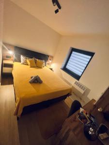 a bedroom with a large yellow bed with a window at Apartment Bjelasnica Dream in Bjelašnica