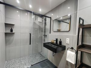 La salle de bains est pourvue d'une douche et d'un lavabo noir. dans l'établissement 85qm, 4 bedroom, parking, King-Bed, Wifi, Netflix, à Waiblingen