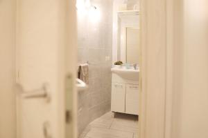 W łazience znajduje się umywalka i lustro. w obiekcie La Corte di Santa Maria w mieście Sassari