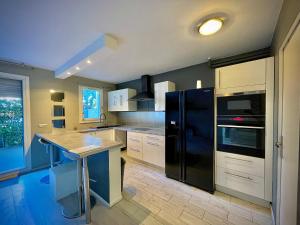 una cucina con frigorifero nero e bancone di Modern Fully furnished Loft In Ermont a Ermont