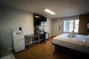 a hotel room with a bed and a desk with a microwave at Envi Boutique Hotel Henderson-Evansville South in Henderson