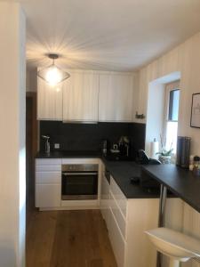 a kitchen with white cabinets and a black counter top at Apart EMMA in Finkenberg