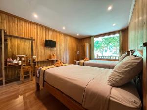 a bedroom with two beds and a desk and a television at Samed Garden Resort in Ko Samed