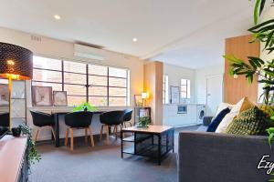 a living room with a couch and a table at MCG 1BR Apartment For Family in Melbourne