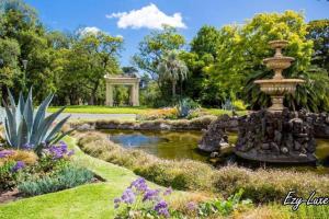 a garden with a fountain in the middle of a pond at MCG 1BR Apartment For Family in Melbourne