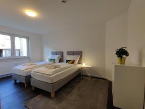 - une chambre avec deux lits et une plante en pot dans l'établissement 85qm, 4 bedroom, parking, King-Bed, Wifi, Netflix, à Waiblingen